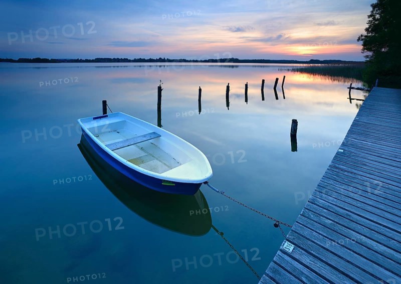 Sunset at Lake Schaalsee, jetty with rowing boat and wooden post in the water, Schaalsee Biosphere Reserve, Zarrentin am Schaalsee, Mecklenburg-Western Pomerania, Germany, Europe
