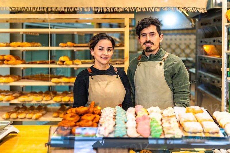 Portrait of a couple of latin young artisans bakery shop owners