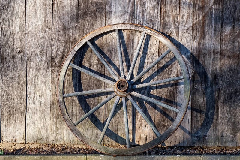 Old wagon wheel leaning against a barn wall, Düstermühle, Legden, district of Wehr, Münsterland, North Rhine-Westphalia, Germany, Europe