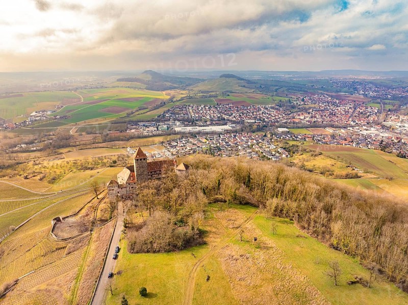 Aerial view of the castle with surrounding dense forests and a neighbouring village under a cloudy sky, Lichtenberg Castle, Oberstenfeld, Germany, Europe