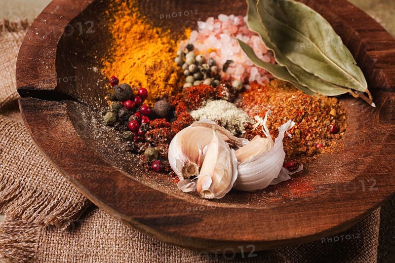 Spice mix, garlic and bay leaf, on a wooden plate, close-up, food concept, no people
