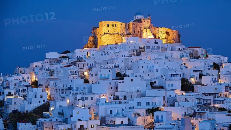Whitewashed buildings surround an illuminated fortress under a dark blue night sky, Querini Castle, Chora, Astypalea, Dodecanese, Greek Islands, Greece, Europe