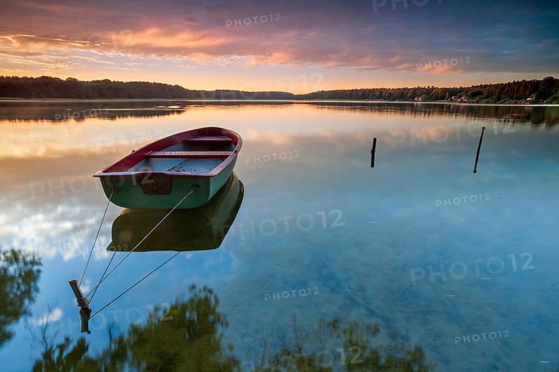 Quiet lake at sunrise, rowing boat moored in the water, Wutzsee, Lindow, Brandenburg, Germany, Europe