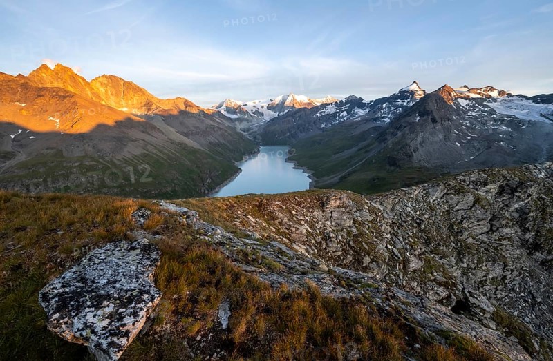 Picturesque mountain landscape at the summit Mont de la Blana at sunset, view of blue mountain lake, reservoir Lac des Dix and summit Mont Blanc de Cheilon with glacier, Hérémence, Valais, Western Alps, Switzerland, Europe