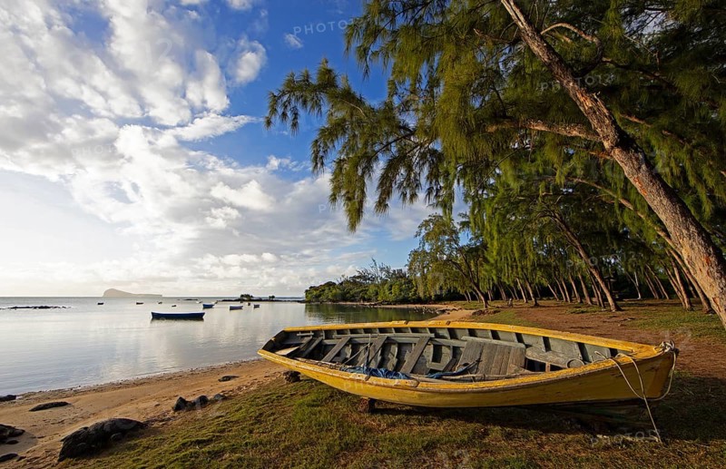 Yellow fishing boat on the beach at Calodyne, Gunner's Coin island in the background, Riviere du Rempart district, Mauritius, Africa