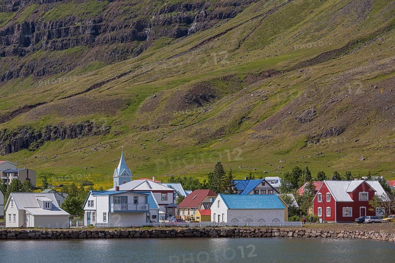 Blue and red houses in Seydisfjordur village on a bright sunny day. E Iceland
