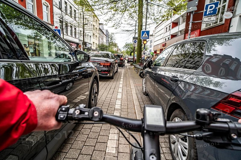 Cycling in the city, inner-city street, cycle lane, bicycles have priority, two-lane traffic with parked cars on both sides, cyclists' perspective, Essen, North Rhine-Westphalia, Germany, Europe
