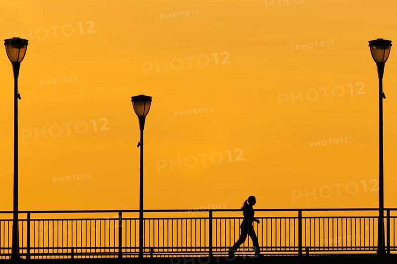 A jogger runs across the Old Bridge in Frankfurt am Main in the early morning shortly in front of sunrise., Frankfurt am Main, Hesse, Germany, Europe