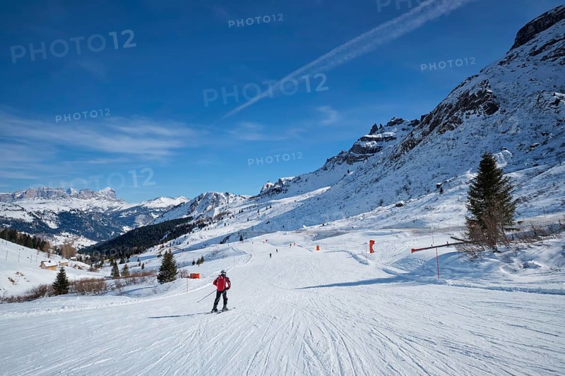 View of a ski resort piste with people skiing in Dolomites in Italy. Canazei, Italy, Europe