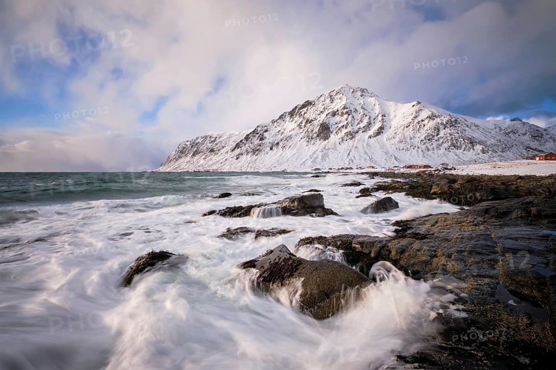 Beach of Norwegian sea on rocky coast in fjord on sunset in winter. Vareid beach, Lofoten islands, Norway, Europe