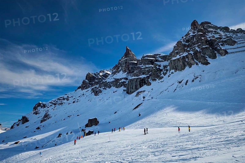 View of a ski resort piste with people skiing in Dolomites in Italy. Ski area Arabba. Arabba, Italy, Europe