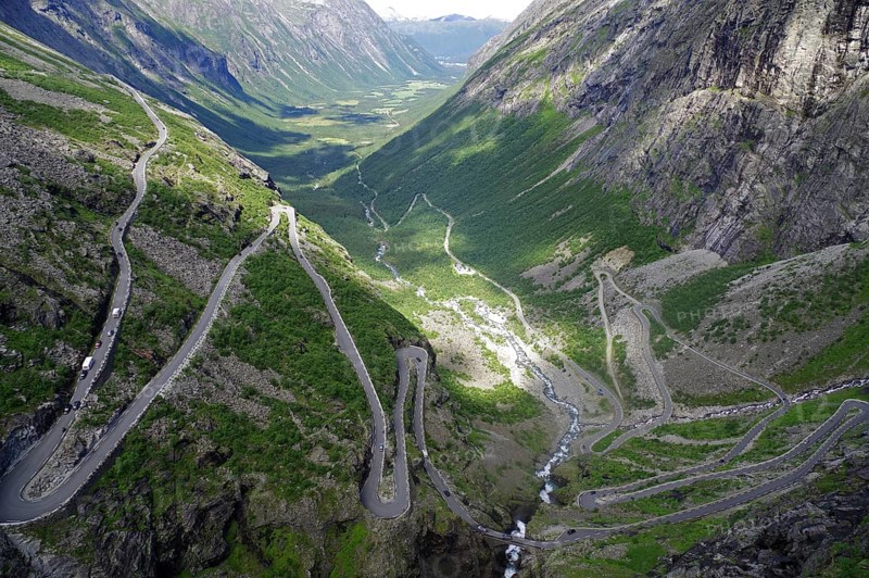 A winding road runs through a green valley between majestic mountains, Trollstigen, Andalsnes, Norway, Europe