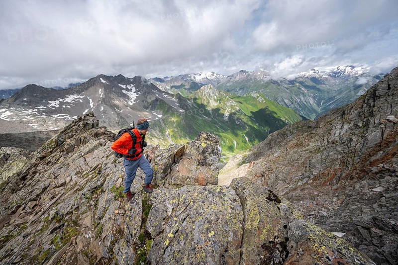 Mountaineer on a steep rocky ridge, at the summit of Lasörling, view of mountains of the Venediger group, Lasörling group, Hohe Tauern National Park, East Tyrol, Tyrol, Austria, Europe