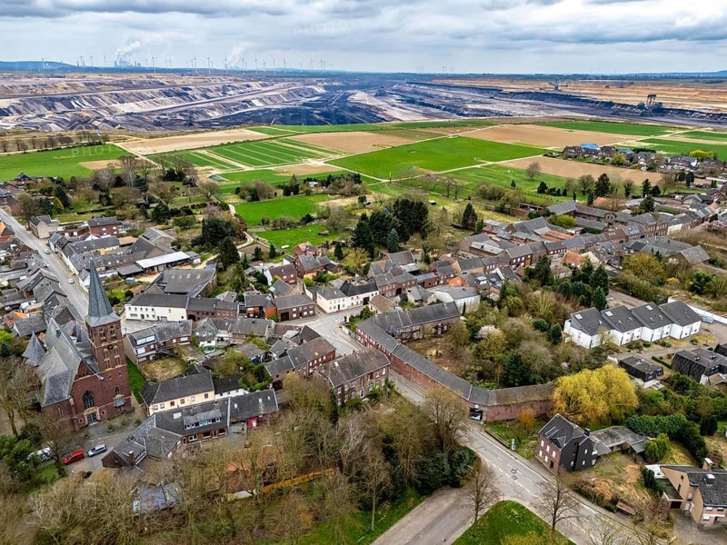 The village of Keyenberg at the Garzweiler II open-cast lignite mining area, the original village was to be dredged, but now remains due to the lignite phase-out in 2030, the former residents now live around 6 kilometres away in the district of Erkelenz, in Keyenberg-Neu, North Rhine-Westphalia, Germany, Europe