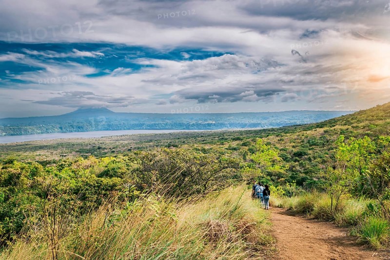 Nature trail overlooking a distant volcano. Landscape of a dirt road overlooking Masaya Lagoon
