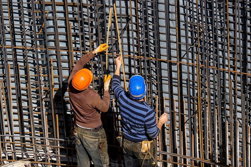 Essen, North Rhine-Westphalia, Germany, construction industry, construction workers working on a building site. Iron binder is a job title for construction workers who bind reinforcing mesh for the reinforcement of concrete parts. The meshes are prepared together with the formwork builder to form moulds, which are then filled with fresh concrete, Europe
