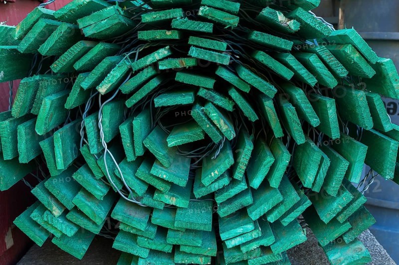 Close-up of rolled fluorescent green painted wood and steel wire snow fence in outdoor storage yard, Quebec, Canada, North America