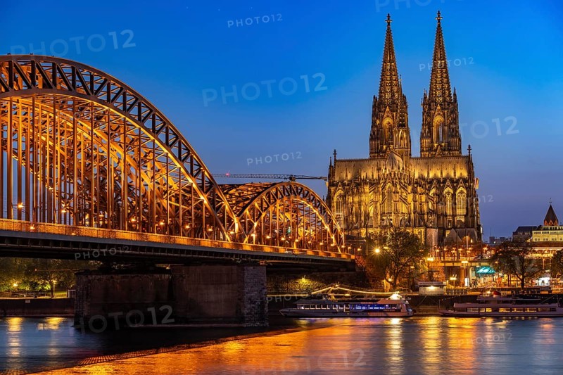 Cologne Cathedral, has been shining in new light since Easter 2025, the old metal halide lamps have been replaced by over 700 modern LED lamps, reducing energy consumption by around four fifths, significantly improving the quality of light and greatly reducing light emissions, 12 KM of new cables were laid for this, Hohenzollern Bridge, railway bridge over the Rhine, North Rhine-Westphalia, Germany, Europe