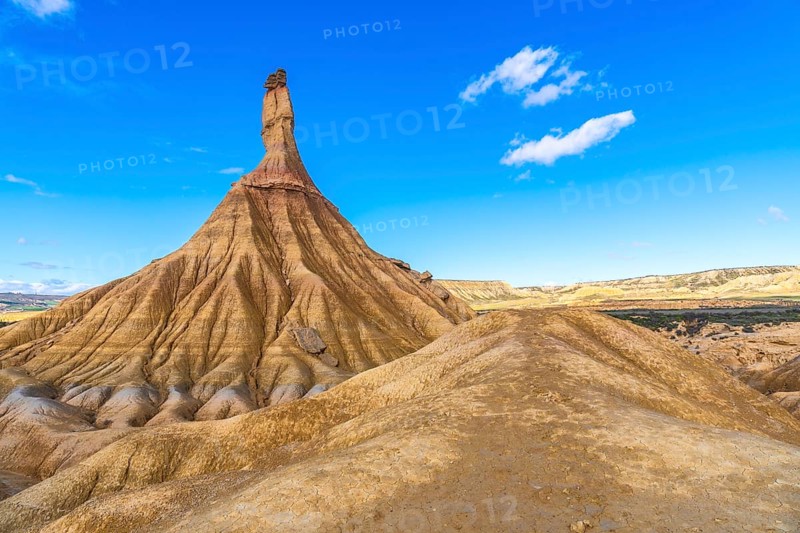 Majestic castildetierra rock formation rising from eroded hills in the bardenas reales desert under a vibrant blue sky
