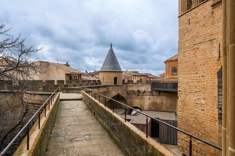 Stone walkway and watchtower rising above the rooftops of olite, offering breathtaking views of the royal palace and surrounding landscape