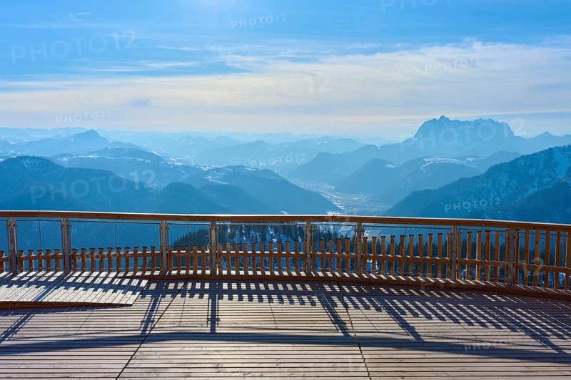 Wooden platform with a view of snow-covered mountains under a blue sky, Steinplatte, Waidring, Tyrol, Austria, Europe