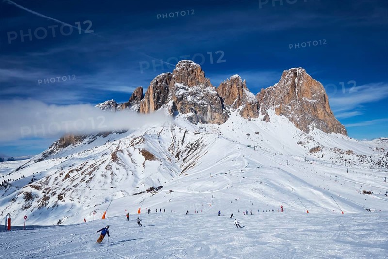 View of a ski resort piste with people skiing in Dolomites in Italy