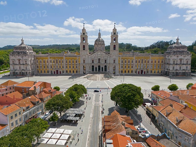 Historic baroque-style palace with yellow façade and two towers, under blue sky and large square, Aerial view, Palace, Palácio Nacional de Mafra, Lisbon, Lisboa, Portugal, Europe