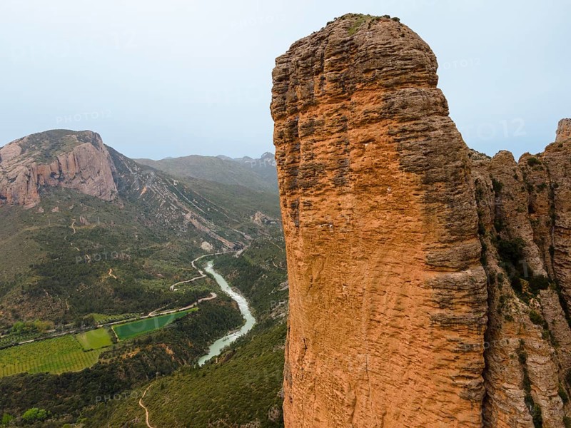 View of a huge rock, a valley with a river below and an impressive natural backdrop, aerial view, Las Peñas de Riglos, As Penyas de Riglos, Mallos de Riglos rock formation, Huesca, Aragon, Spain, Europe