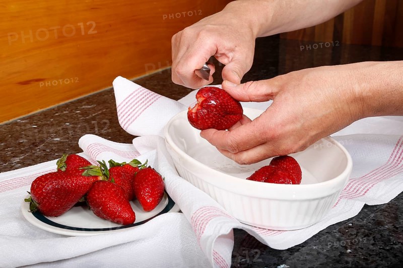 Swabian cuisine, preparation of filled pancakes, Flädle with strawberry jam and icing sugar, Gsälz, fresh strawberries, cutting berries, slicing, sweet, dessert, dessert, arranged on plate, grandmother's kitchen, regional, home cooking, typical Swabian, Swabian kitchen classic, traditional cuisine, men's hands, knife, food photography, studio, Germany, Europe