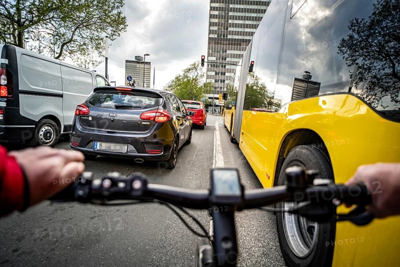 Cycling in the city, city centre road, no cycle path, bus stop, two-lane traffic in both directions, cyclists' perspective, Essen, North Rhine-Westphalia, Germany, Europe