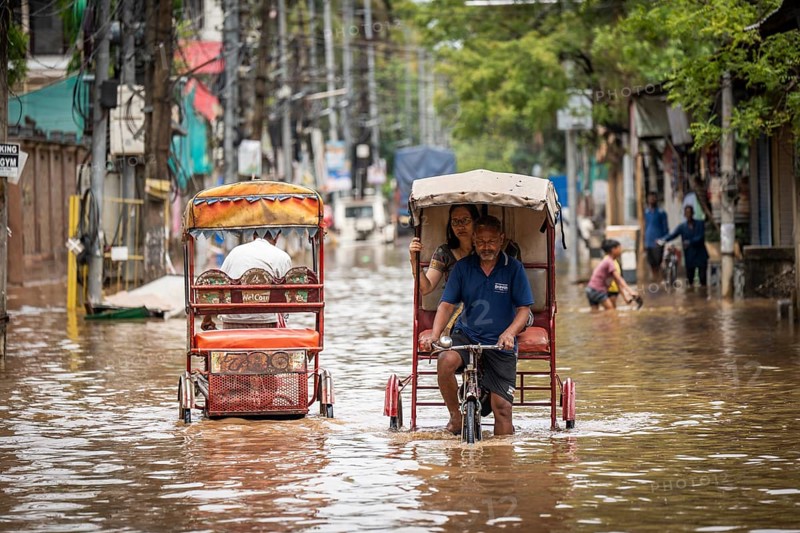 Commuters in cycle rickshaws as they wade through a flooded street after heavy rains in Guwahati, India on April 28, 2025