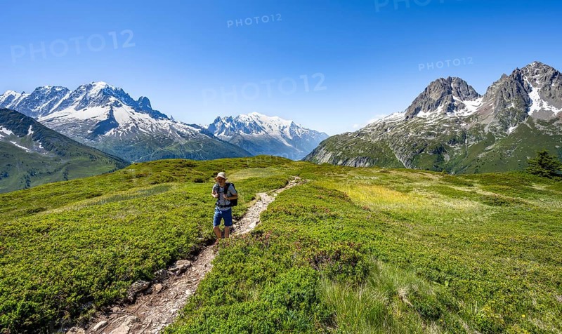 Mountaineer on hiking trail in front of mountain panorama with glaciated mountain peaks, Aiguille Verte with Aiguille du Midi and Mont Blanc, hike to Aiguillette des Posettes, Chamonix, Haute-Savoie, France, Europe