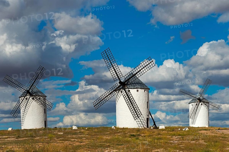 Three windmills in front of a dramatic sky with imposing clouds, Campo de Criptana, Ciudad Real province, Castilla-La Mancha, Don Quixote Route, Spain, Europe