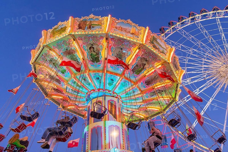 Illuminated carousel and Ferris wheel at night in a lively amusement park, funfair, wave flight, Cannstadter Volksfest, Stuttgart-Bad Cannstsdt, Baden-Württemberg