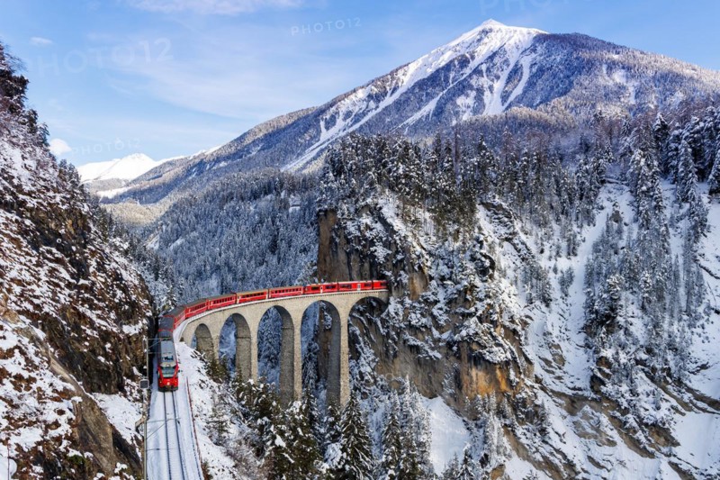 Rhaetian Railway train at the famous Landwasser Viaduct on the Albula railway Stadler Rail passenger train in the Alps in Filisur, Switzerland, Europe