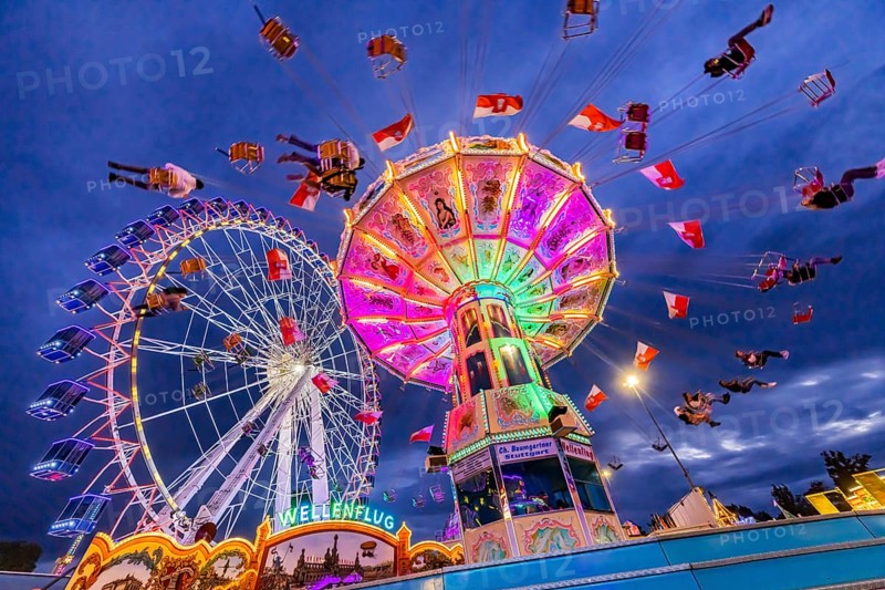 Chain carousel and Ferris wheel in the evening. 177th Cannstatter Volksfest at the Cannstatter Wasen. Bad Cannstatt, Stuttgart, Baden-Württemberg, Germany, Europe