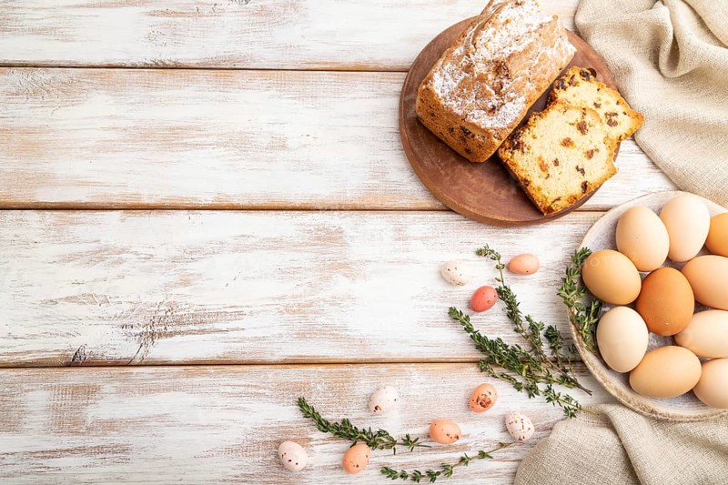 Homemade easter pie with raisins and eggs on plate on a gray concrete background and linen textile. top view, flat lay, copy space