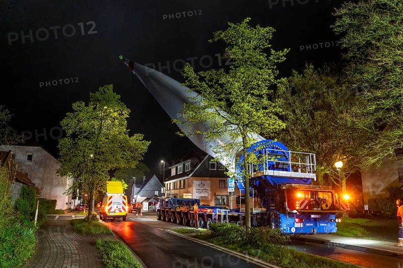 Transport of a 68 metre long, 22 tonne blade of a wind turbine, here in Breckerfeld-Waldbauer, with a self-propelled Blade-Lifter vehicle, over a 40 km long route, over 2 nights, in the Bergisches Land, through towns, villages, on country roads, narrow through roads, to the construction site of the wind turbine near Hagen, North Rhine-Westphalia, Germany, Europe