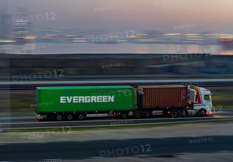 Lorry on the road from Euromax Terminal Rotterdam, ENECO wind farm on the dike around the port of Maasvlakte 2, 22 wind turbines with a capacity of 116 megawatts, sunset, Rotterdam, Netherlands Evergreen Container