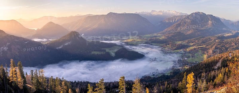 Panoramic photo. View from Mount Loser to Lake Altaussee, Altaussee, Bad Aussee, Tressenstein, Zinken, Sarstein, Dachstein mountains. Wafts of mist over the lake. In the morning at sunrise. Blue sky. Autumn, yellow larches. Altaussee, Bad Aussee, Ausseer Land, Totes Gebirge, Styria, Upper Austria, Austria, Europe