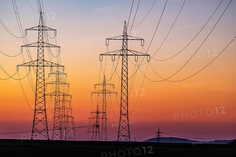 High-voltage pylons, overhead power lines at sunset. Schwieberdingen, Baden-Württemberg, Germany, Europe