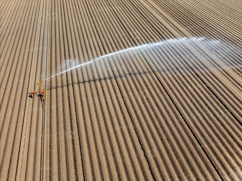 Artificial irrigation of a potato field in April, with a sprinkler system, long drought in spring makes this necessary, for the total of 7.5 hectares 3 full days are needed to get the necessary moisture for the freshly sown potato plants, south of Straelen, Lower Rhine, North Rhine-Westphalia, Germany, Europe
