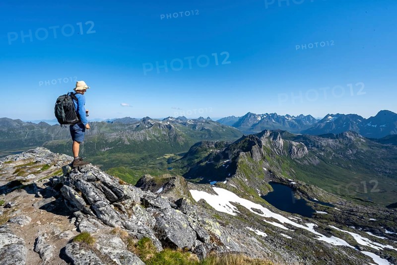 View of mountain landscape, mountain panorama, mountaineer at the summit of Rundfjellet, lake Hellskarvatnet, Svolvaer, Nordland, Norway, Europe