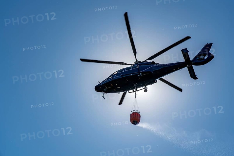 Forest fire in the German-Dutch border region near Niederkrüchten-Elmpt, in a nature reserve, deployment of fire-fighting helicopters, Eurocopter EC 155, Federal Police with extinguishing water tank, Bambi Bucket