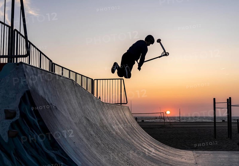 Skater, scooter in a halfpipe at the beach of Scheveningen, sunset, Netherlands