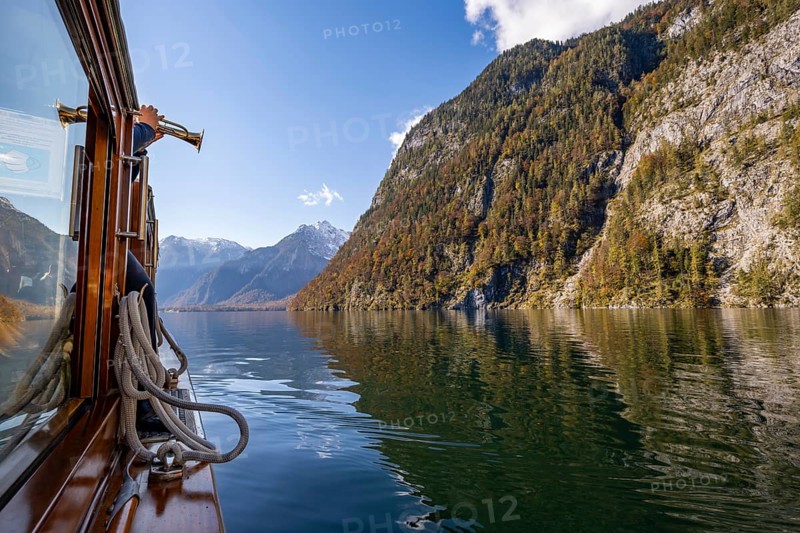 A trumpet is played on the echo wall of a tourist boat, Königssee, autumnal mountain landscape reflected in the lake, Berchtesgaden National Park, Berchtesgadener Land, Upper Bavaria, Bavaria, Germany, Europe
