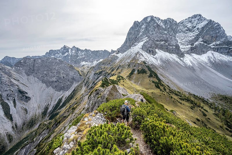 Mountaineers on a hiking trail on the ridge of Hahnkampl, mountain panorama with rocky steep peaks, view of summit Lamsenspitze, in autumn, Karwendel Mountains, Alpenpark Karwendel, Tyrol, Austria, Europe