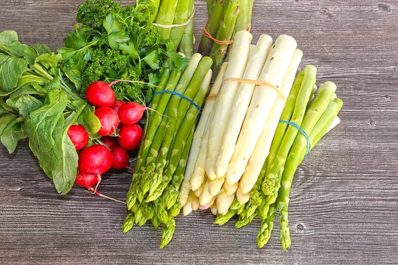 Green asparagus and white asparagus decorated on a rustic wooden table