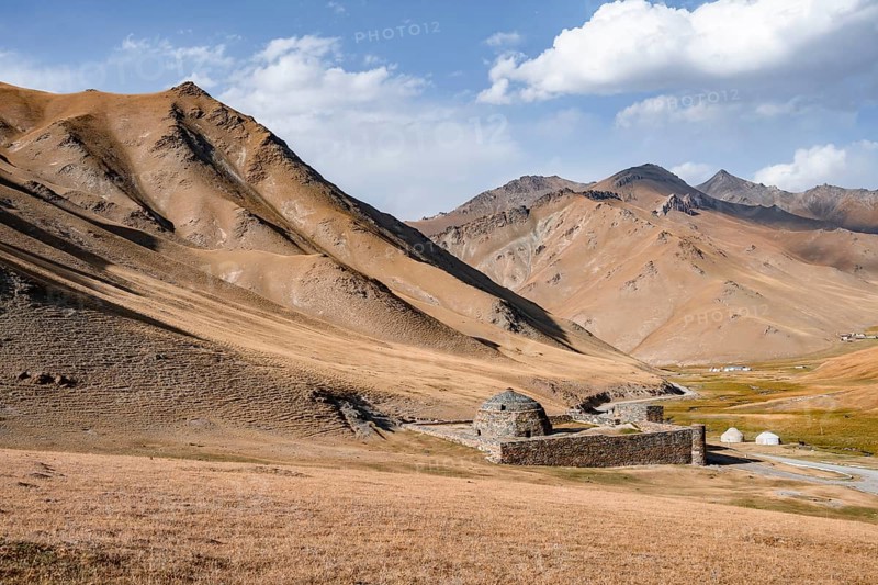 Historic caravanserai Tash Rabat from the 15th century, with yellow hills, Atbashy district in the Naryn region, Kyrgyzstan, Asia
