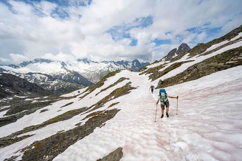 Two mountaineers crossing a snowfield, ascent to the Nördliche Mörchnerscharte, mountain peak with snow and glacier in the background, Berliner Höhenweg, Zillertal Alps, Tyrol, Austria, Europe